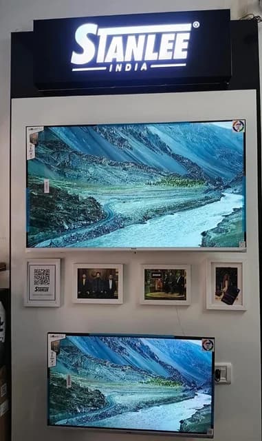 The Shahdara store — lit Stanlee signage above a display wall with the Shark Tank photographs framed beneath